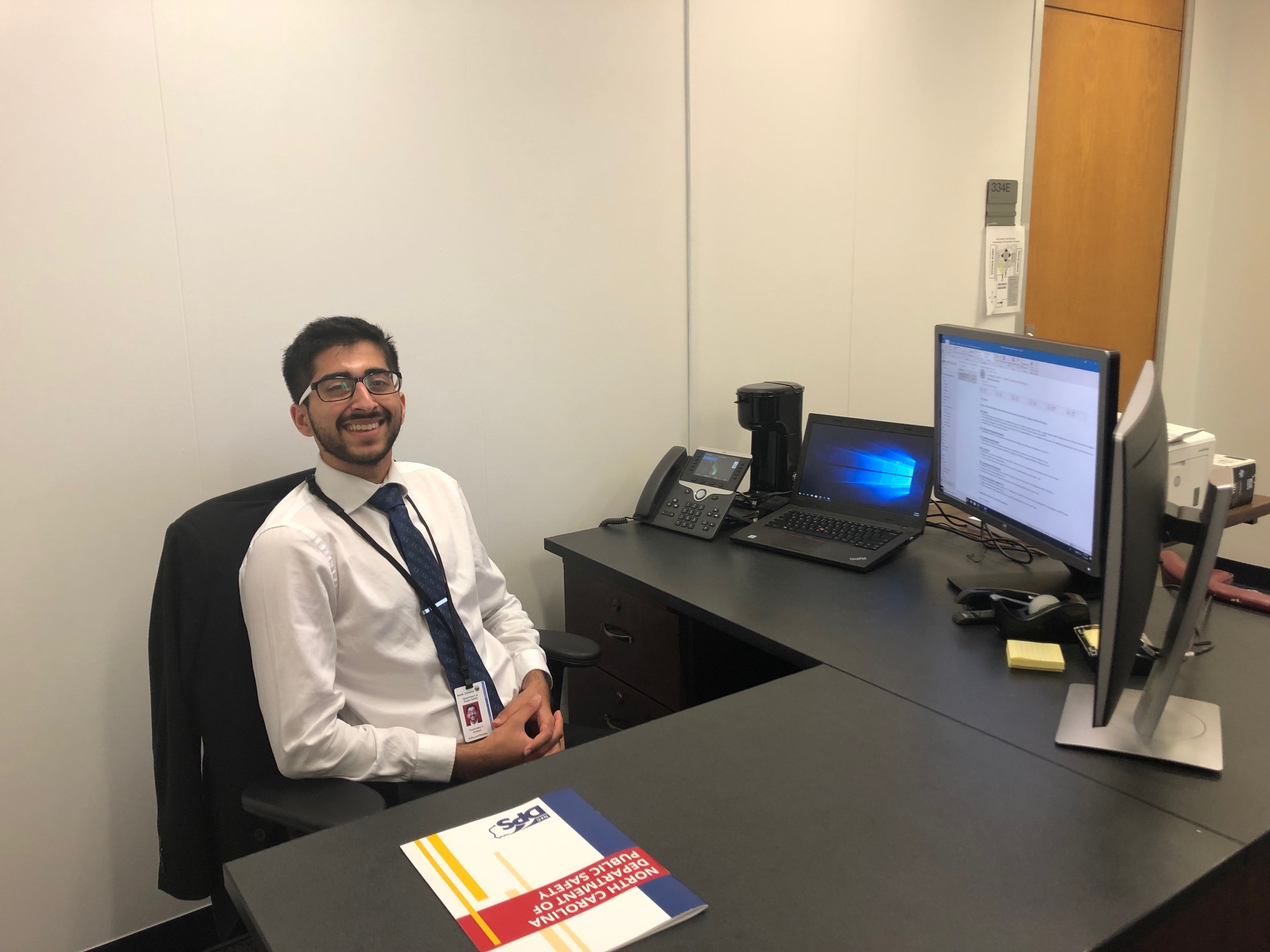 Carolina senior Purshotam Aruwani at his desk in the N.C. Department of Public Safety, during his 2019 APPLES Service-Learning summer internship.