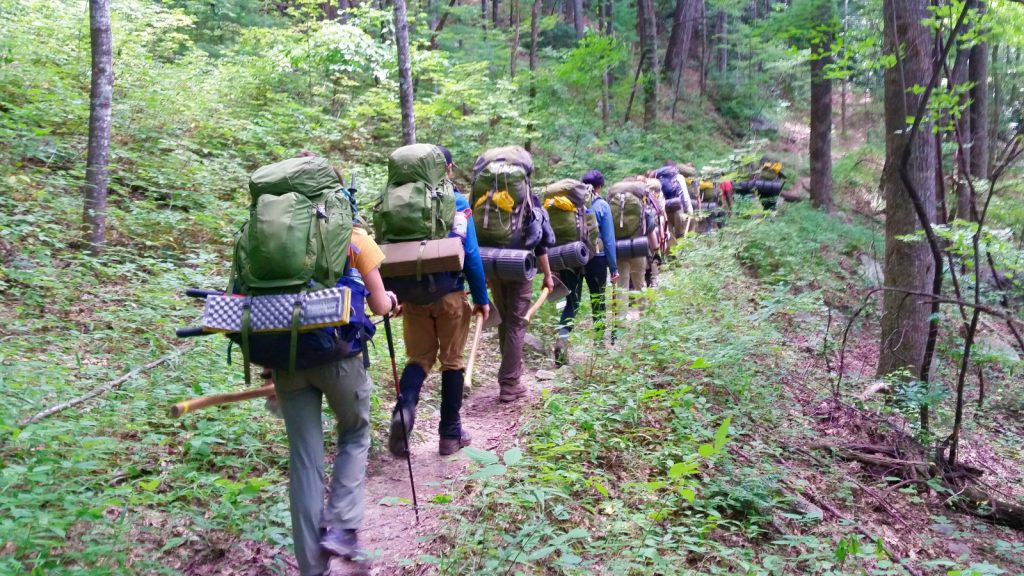 Backpackers hiking down a dirt trail