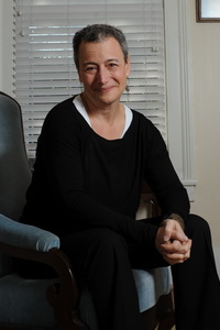 Della Pollock sitting on the edge of chair smiling