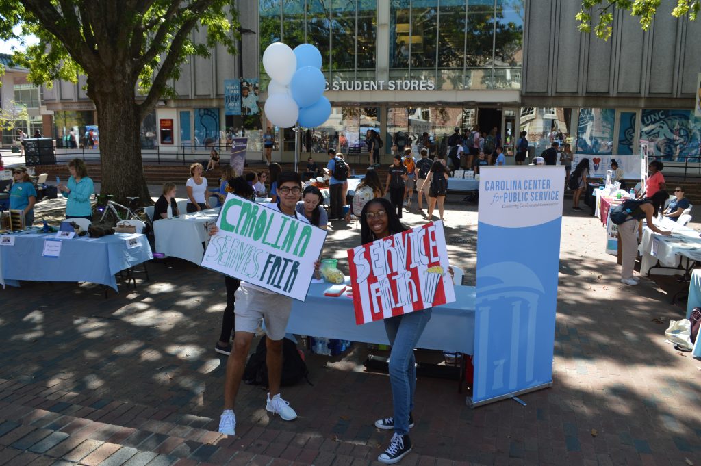 Students holding up signs at the 2019 Public Service Fair in The Pit